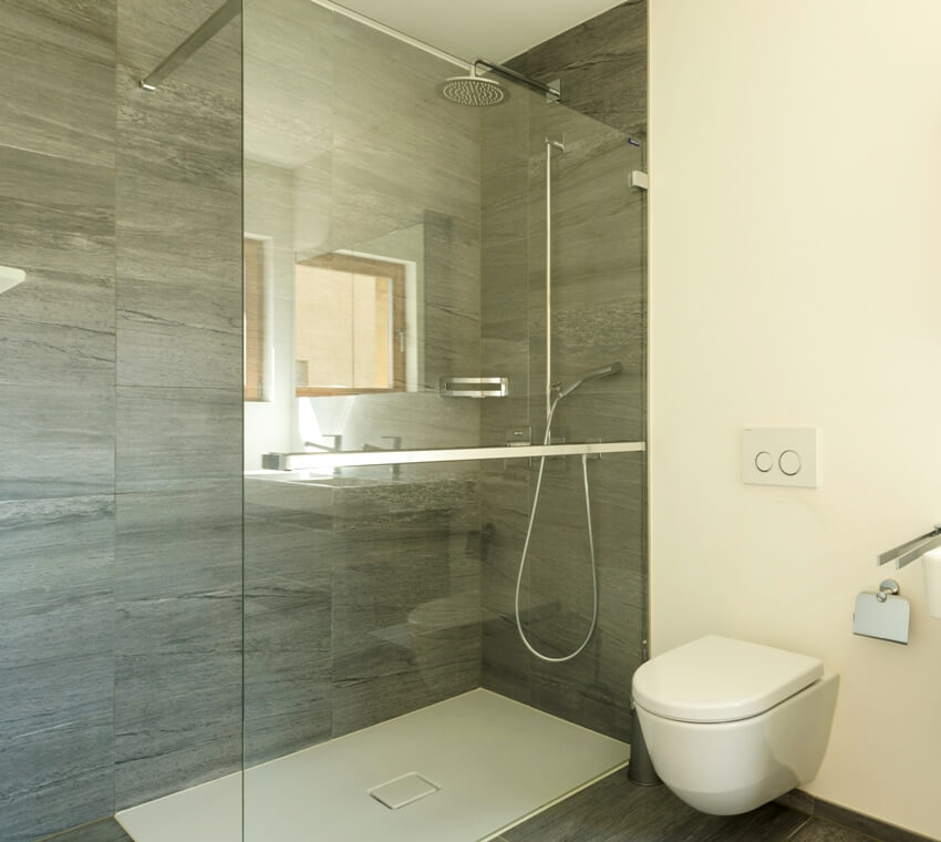 Empty modern bathroom interior with shower and gray stone like laminate walls