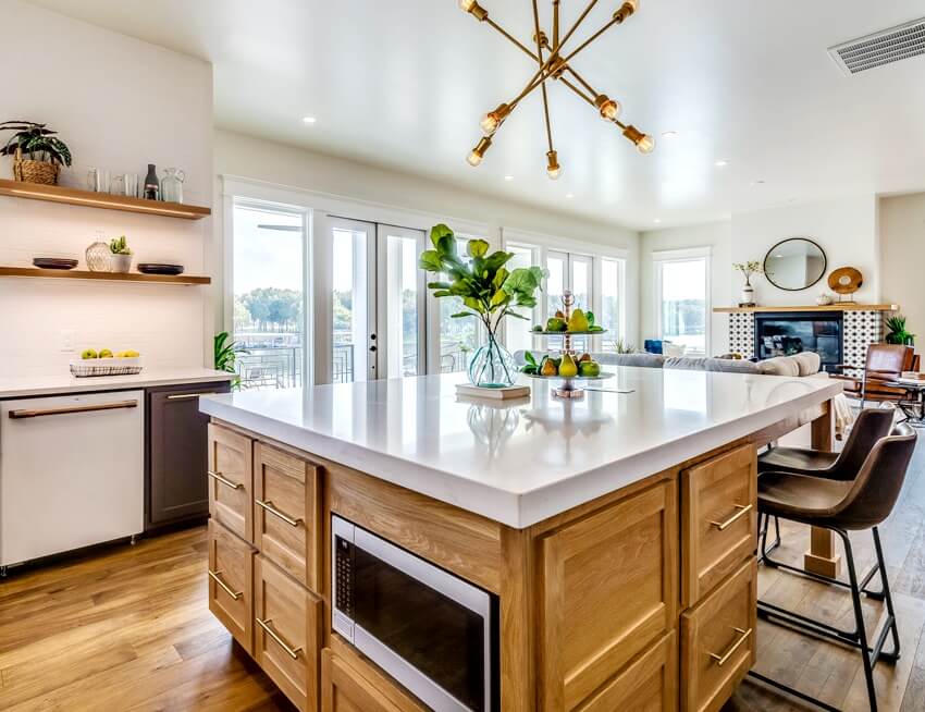 Farmhouse style kitchen with modern pendant light hanging over small island with ultra compact countertop