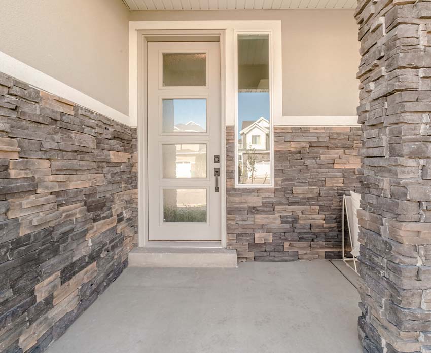 Front porch with gneiss stone siding, and glass door