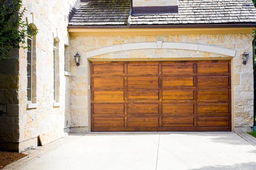 Garage with siding made of stone and wood door