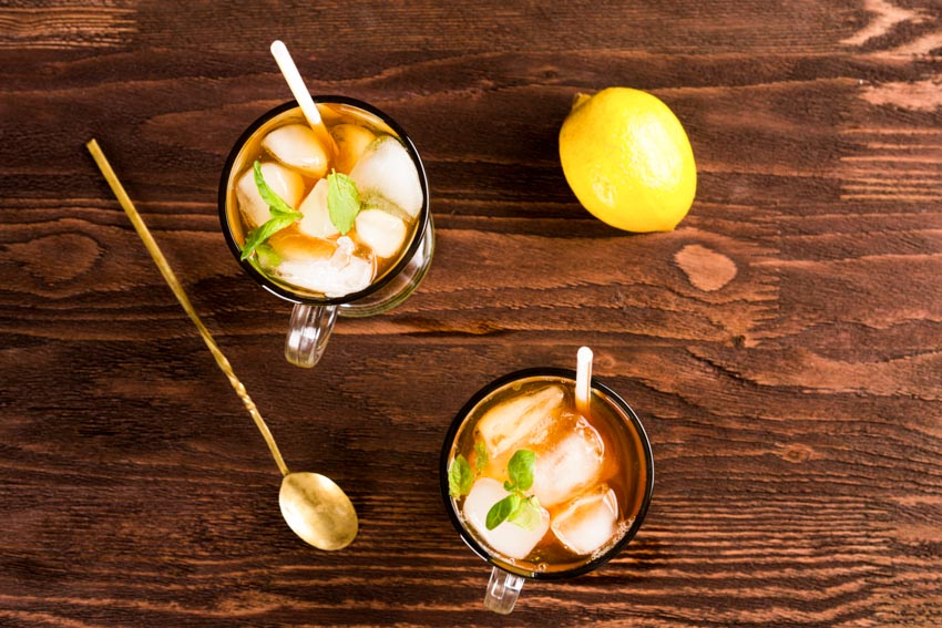 Glasses containing tea lemon and iced tea spoon