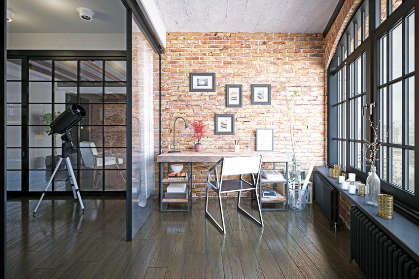 Home office with room divider, wood floor, table, chairs, and brick accent wall