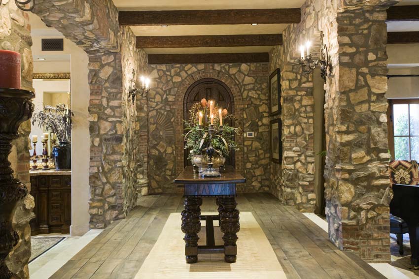 House interior with stone look floating vinyl tiles, stone walls, table, and centerpiece