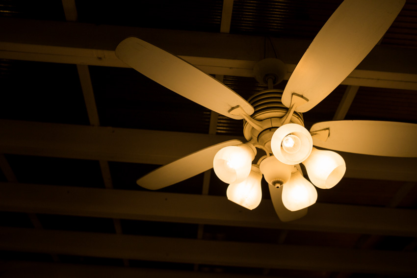 Interior ceiling with wood beams, ceiling fan, and lighting fixture