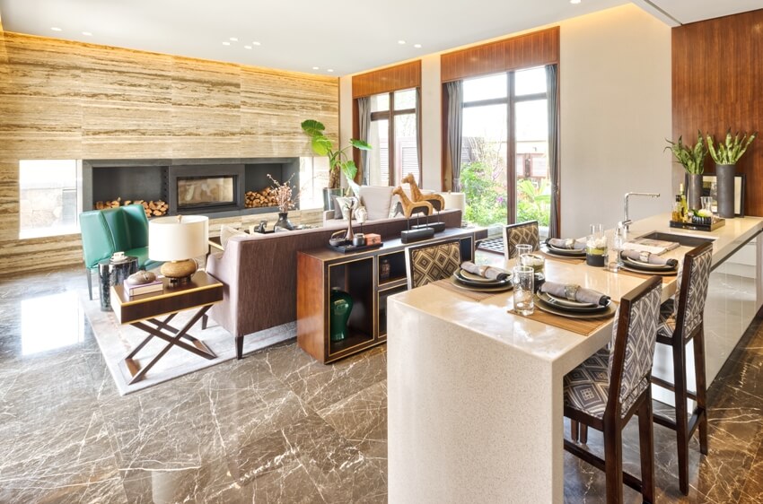 Kitchen counter with dining set up and a view of a furnished living room with granite floors