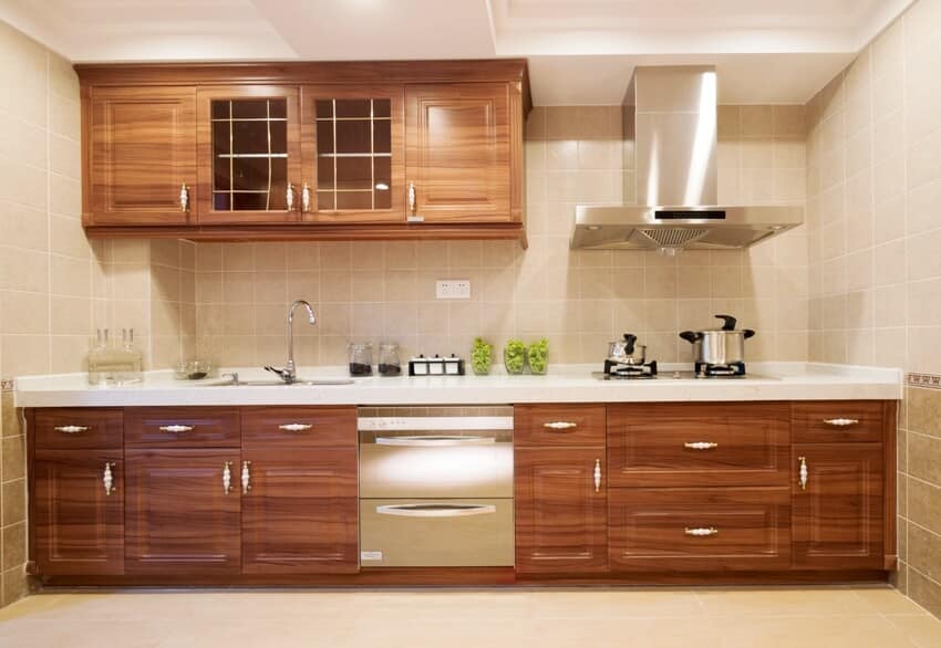 Kitchen interior showing solid teak cabinets, stainless steel appliances and tile backsplash and floors