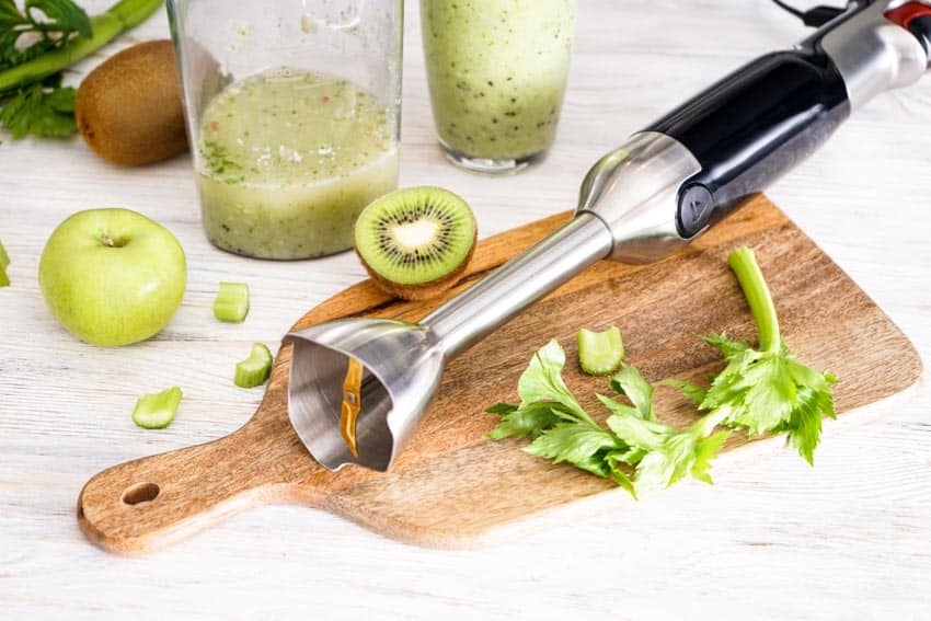 Immersion blender, sliced kiwi fruit and cutting board