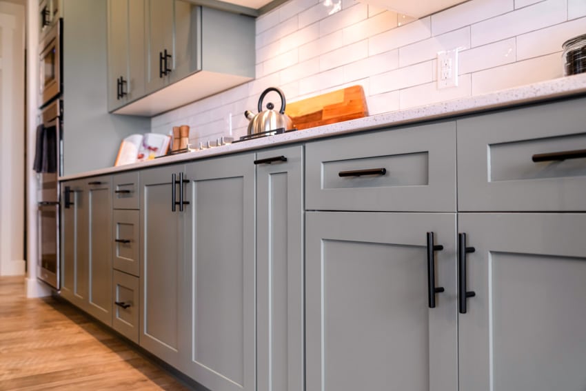 Kitchen with cabinet hardware, tile backsplash, and wood flooring