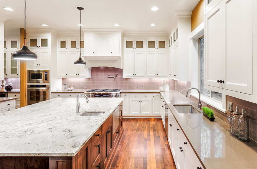 Kitchen with cabinet knobs, two tone cabinets, gray quartz marble countertops, and Tigerwood flooring
