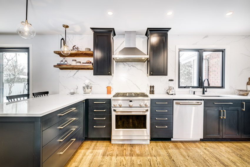 Kitchen with cabinets, range hood, quartzite backsplash, floating shelves, oven, windows, and wood flooring