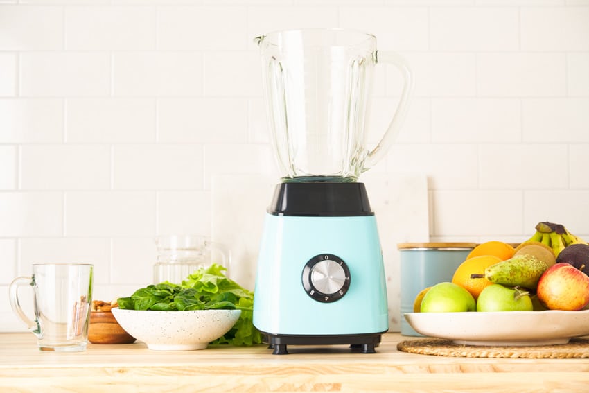 A blue green blender with control knob