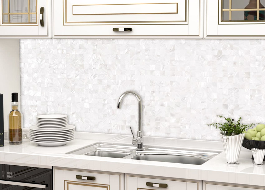 Kitchen with countertop, sink, faucet, cabinets, and peel and stick Mother of Pearl backsplash