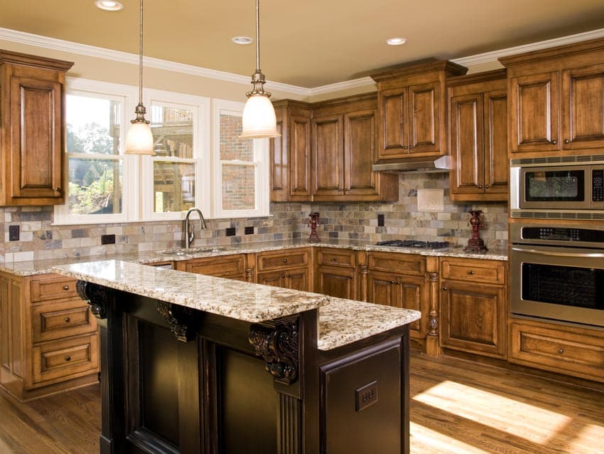 Kitchen with delicatus cream granite countertop, pendant lights, backsplash, wood flooring, cabinets, and windows