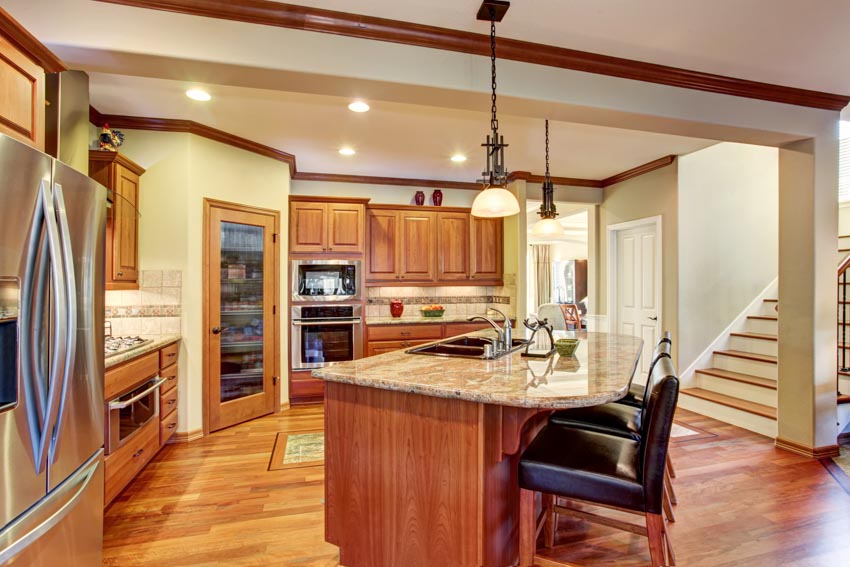 Kitchen with engineered Tigerwood flooring, island, chairs, countertop, pendant lights, cabinets, and refrigerators