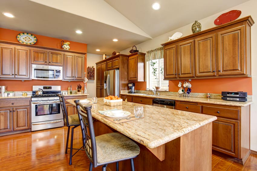 Kitchen with imperial gold granite countertops, island, backsplash, wood cabinets, and ceiling lights