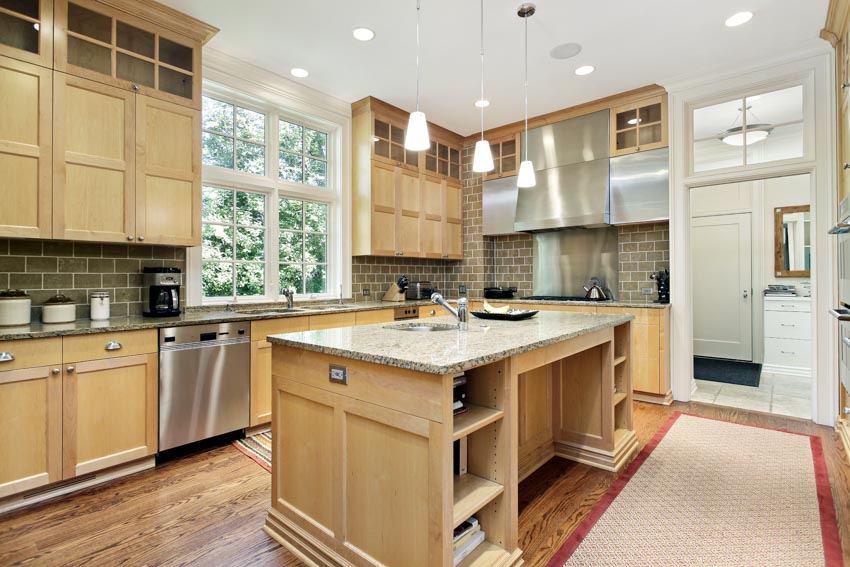 Kitchen with island, maple cabinets, tile backsplash, wood cabinets, window, hanging lights, and wooden floors