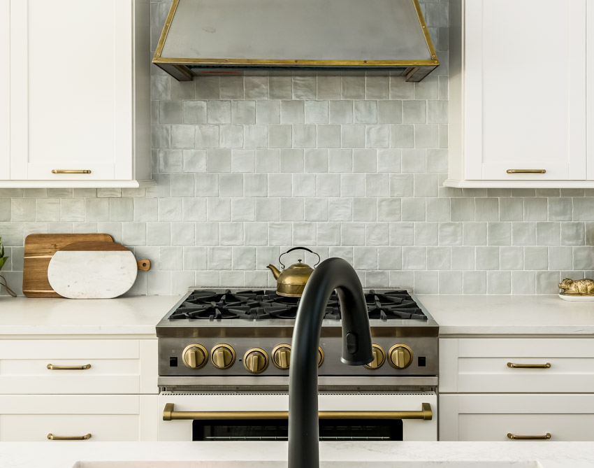 Kitchen with brass-trimmed hood, countertop, cabinets and drawers