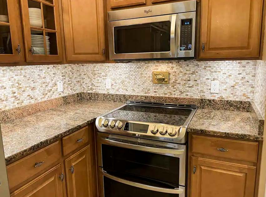 Kitchen with backsplash tile, wood cabinets, stove, oven, and countertops