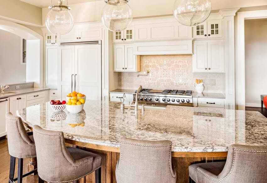 Kitchen with peninsula, chairs, cream granite countertop, backsplash, and white cabinets