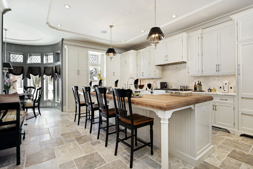 Kitchen with butcher block island and travertne flooring tile