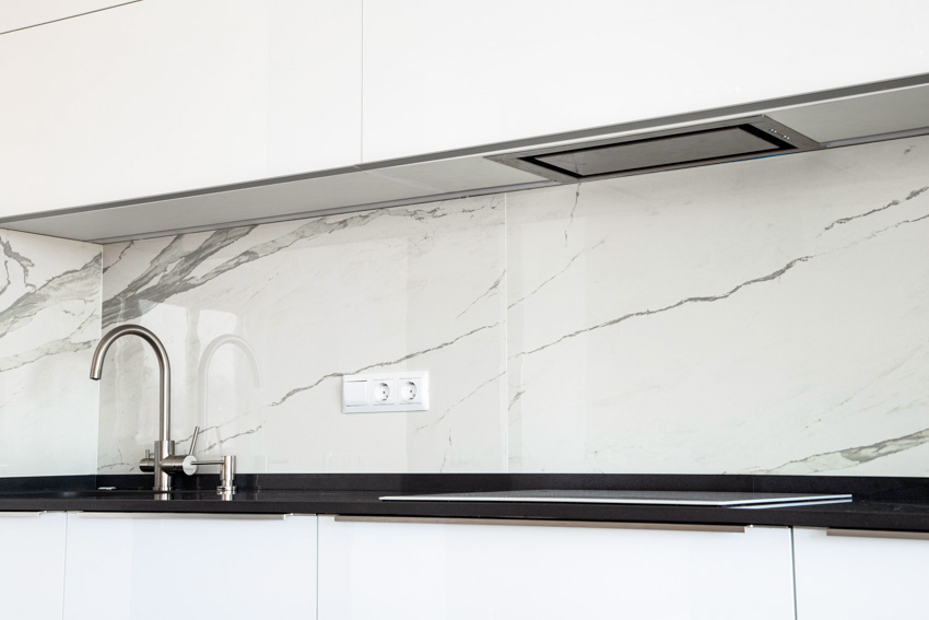 Kitchen with quartzite slab backsplash, faucet, and countertop
