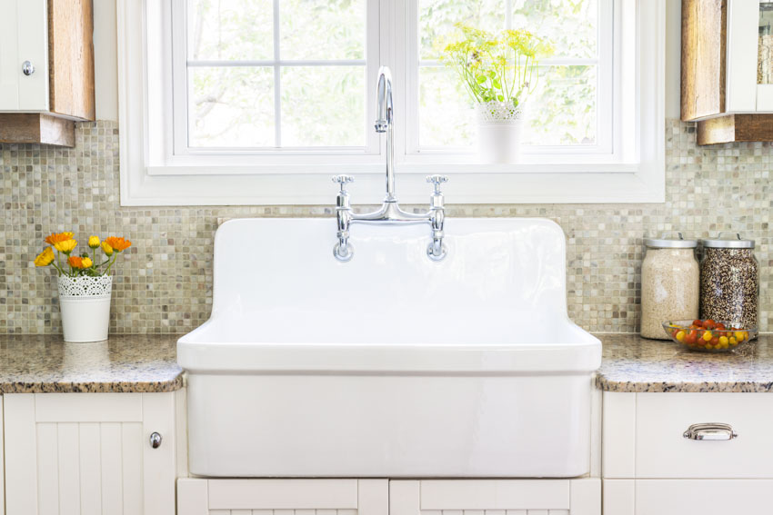 Kitchen with white sink, countertop, faucet, drawer and window