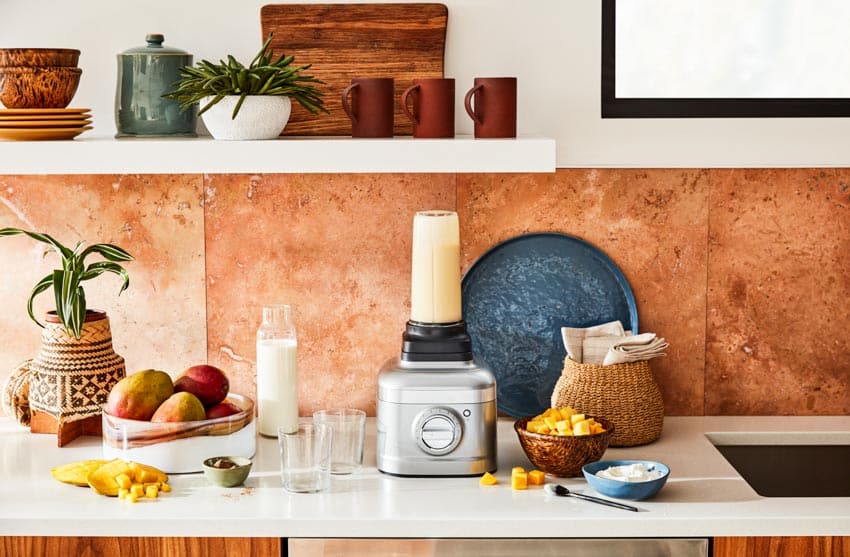 Kitchen with smoothie blender, backsplash, countertops, and shelves
