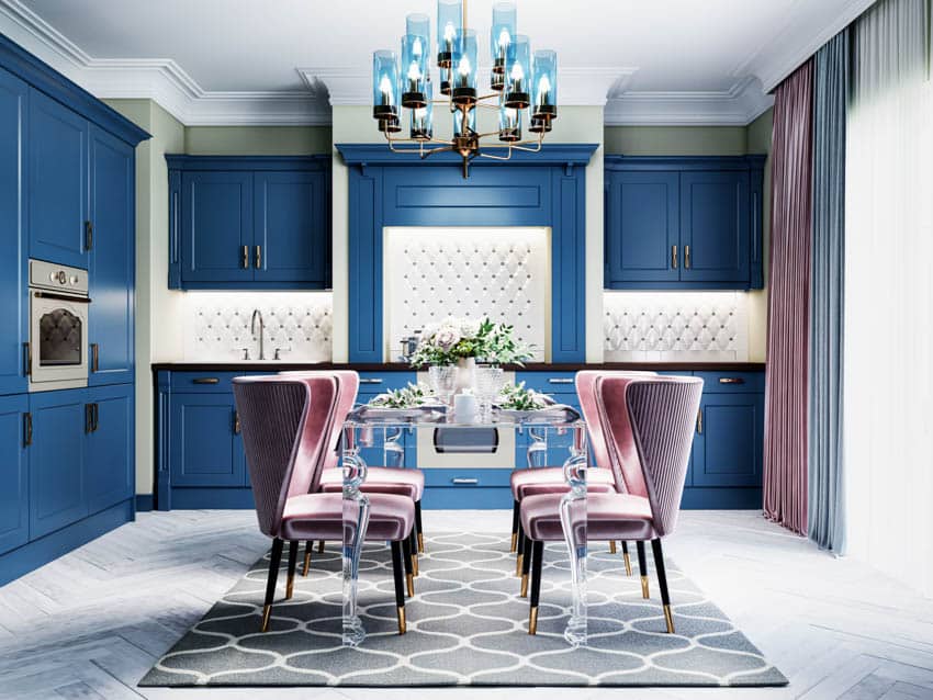 Kitchen with table, chairs, chandelier, blue cabinets, countertop, and backsplash
