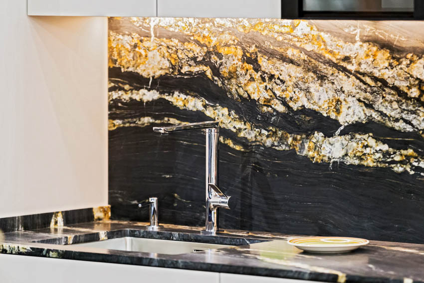 Kitchen with titanium gold granite countertop, backsplash, sink, and faucet