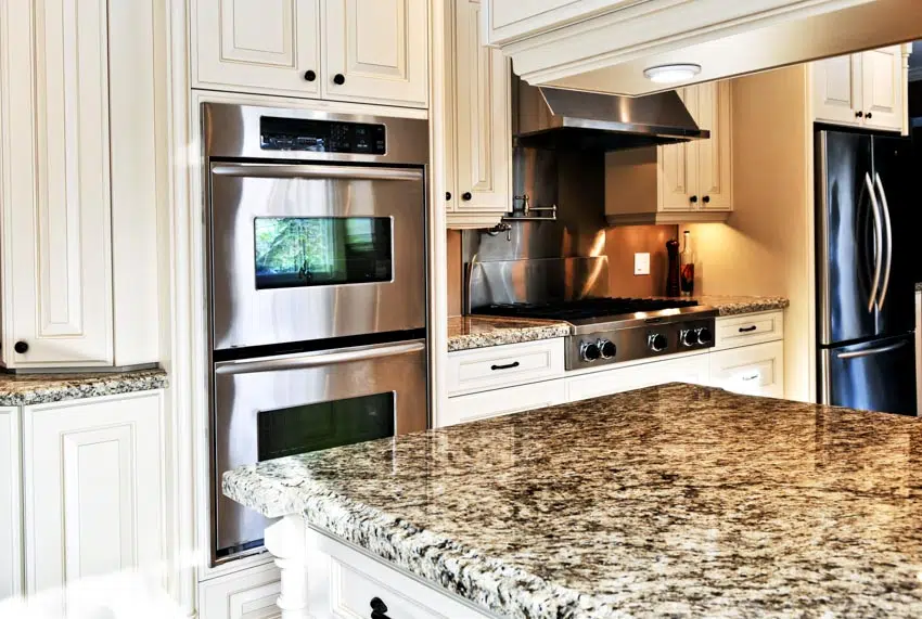 Kitchen with white cabinets, oven, antico cream granite 