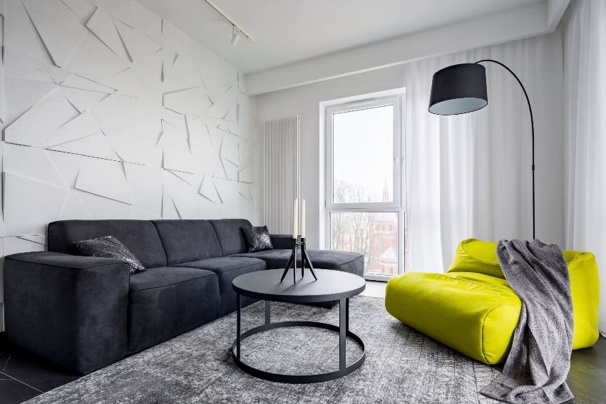 Modern living room in white black and lime green with sack couch, round table and sofa