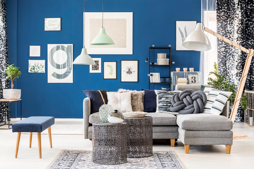 Room with analogous pairing of gray furniture, sofa, coffee table, small ottoman and pendant light