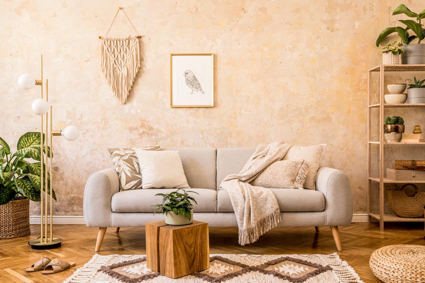 Room with earthy tones, rug, freestanding shelves, indoor plants, and wood flooring