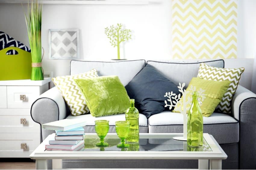 Cozy living room with white center table, gray sofa, lime green and black throw pillows 