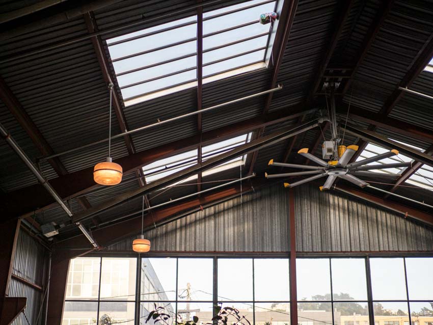 Metal barn with industrial ceiling fan, skylight window, and lighting fixtures