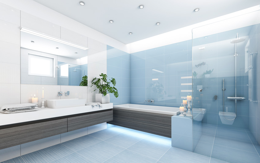 Modern bathroom with glass tile shower, tub, floating vanity, mirror, countertop, and sink