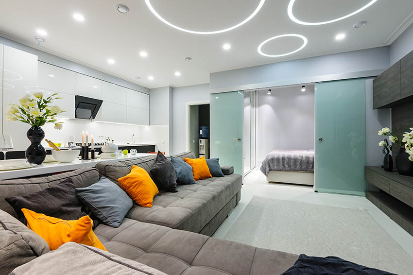 Modern living room with glass aqua sliding double doors orange pillows gray couch