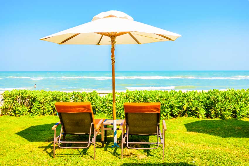 Outdoor lawn with offset umbrella and lounge chairs