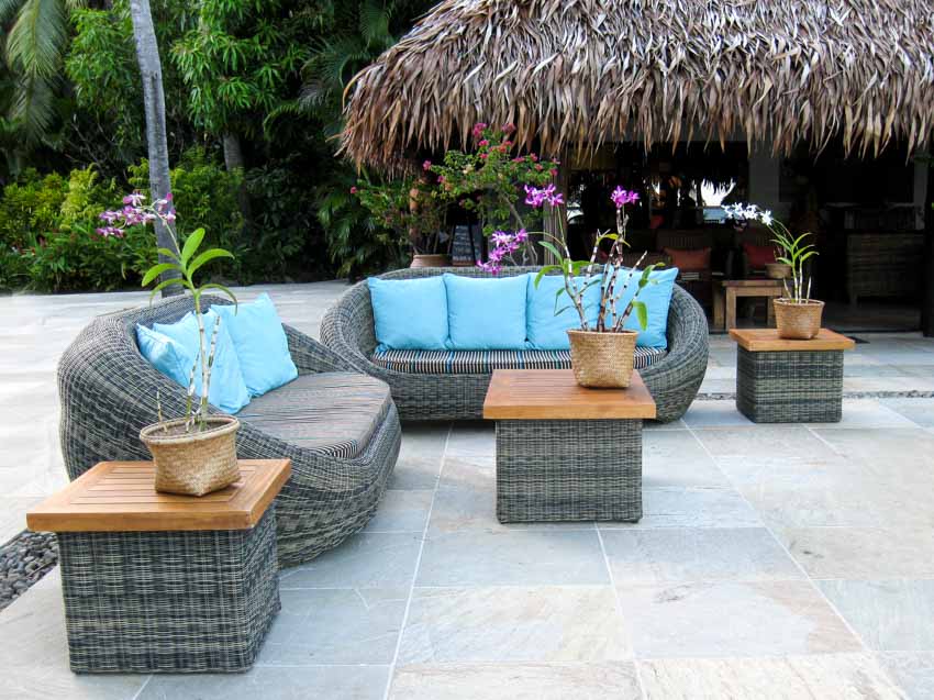 Outdoor patio with porcelain pavers, sofa, side tables, and pillows