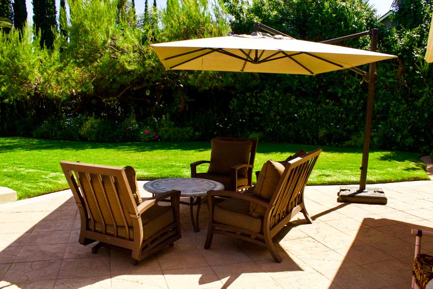Outdoor patio with table, chairs, and pavers and offset umbrella