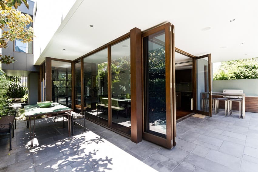 Outdoor patio with bifold doors, resin pavers, and outdoor furniture