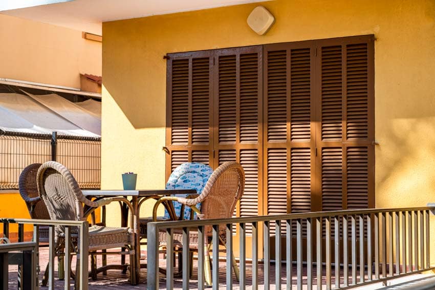 Outdoor patio with wood louvered doors, table, and chairs