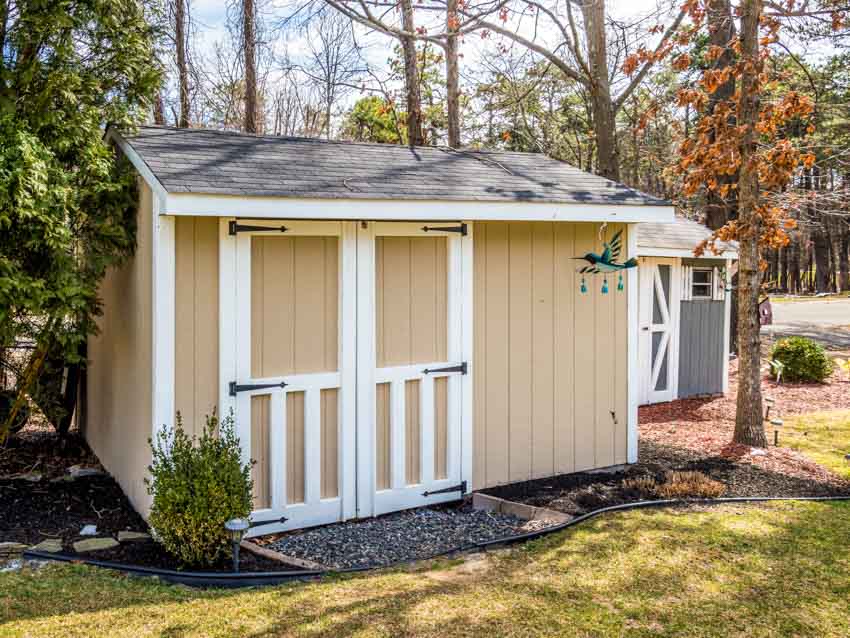 Outdoor shed with roof, gravel base, and door