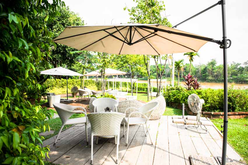 Outdoor wood deck with chairs, table, and offset umbrella