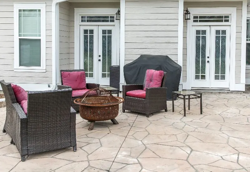 Patio with chairs and concrete flooring with grey grout