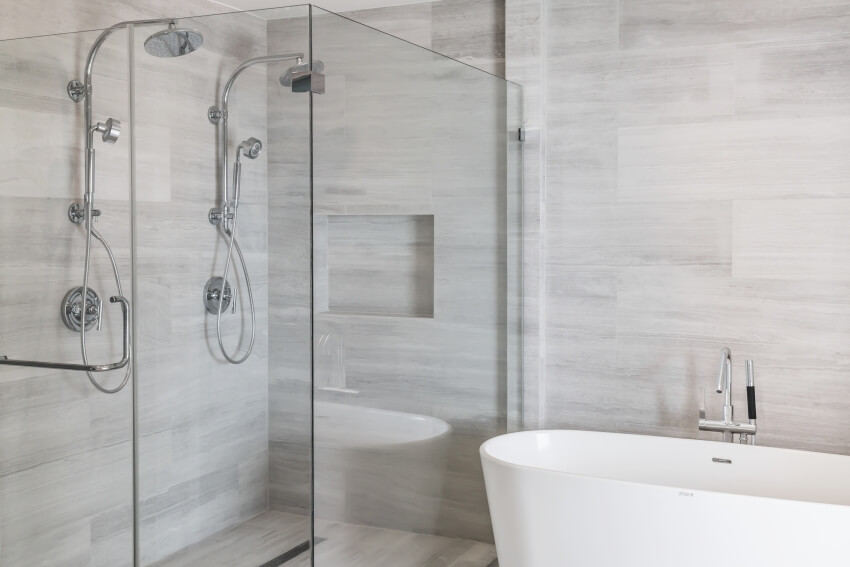 Shower with laminate walls, glass division and a freestanding bathtub
