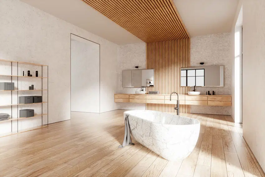 Bathroom with marble bathtub, double basin, vanity space and wood plank flooring