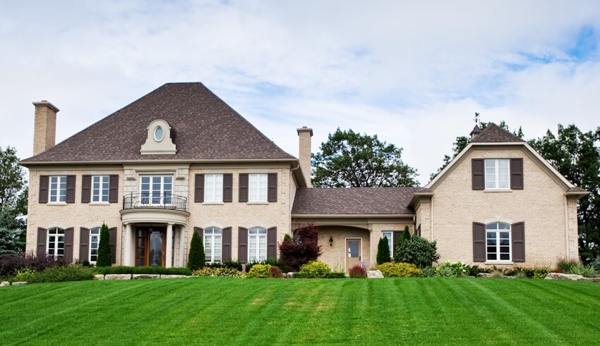 Stunning luxury brick residence with well landscaped yard ,large windows with brown shutters and door entrance