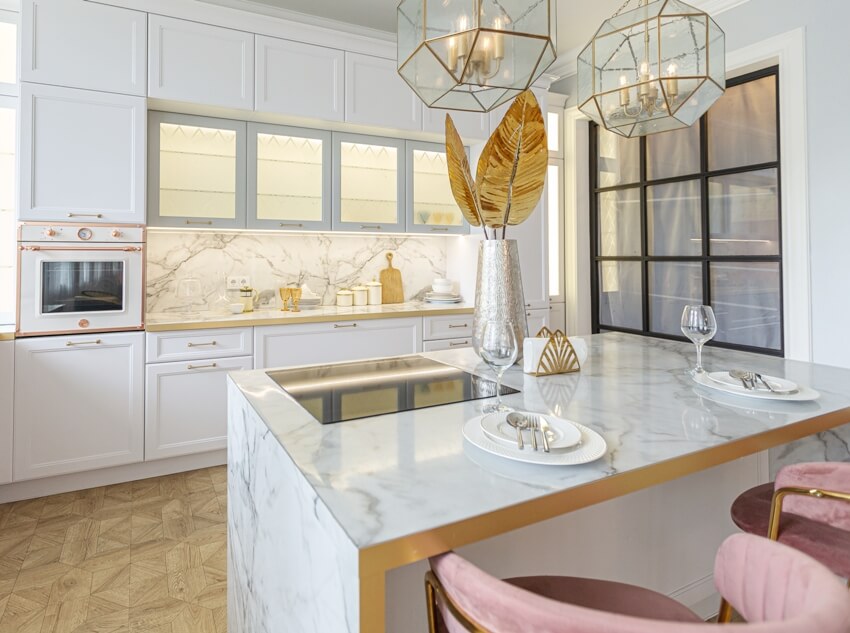 White kitchen with a cooking island and and pink chairs