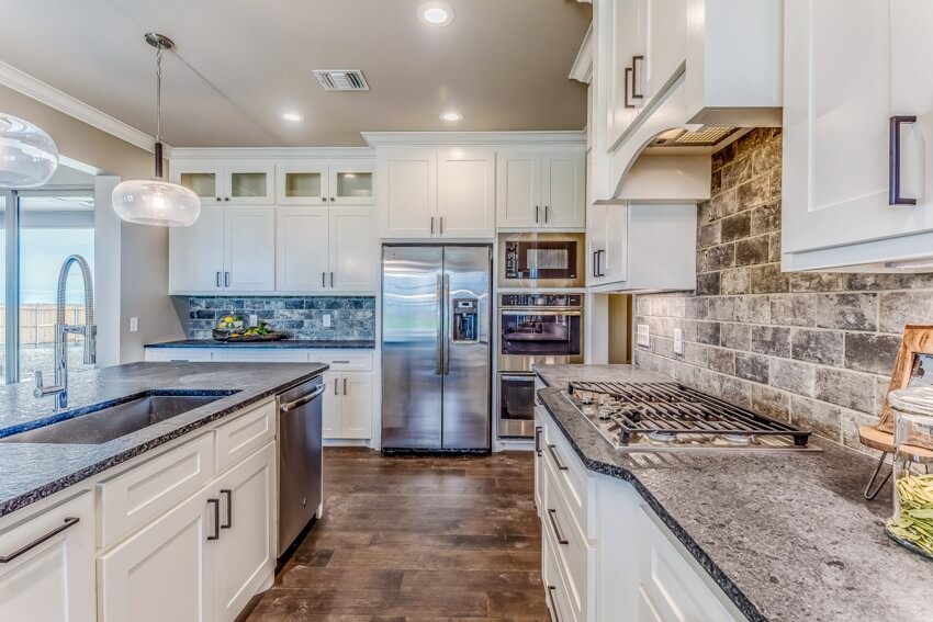 Kitchen with white cabinets, stainless steel appliances and island in white finish
